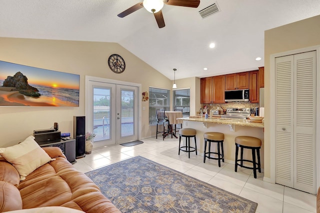 living room with french doors, sink, vaulted ceiling, light tile patterned floors, and ceiling fan