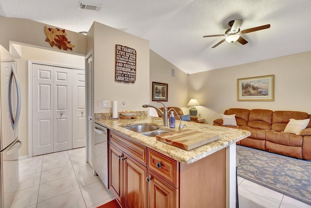 kitchen with lofted ceiling, sink, a textured ceiling, light tile patterned floors, and stainless steel appliances