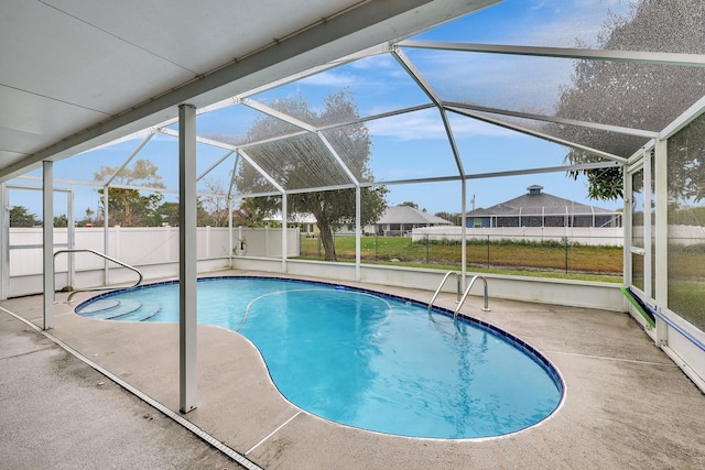 view of pool with a patio and glass enclosure