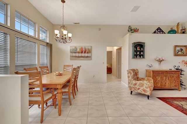 tiled dining room with an inviting chandelier