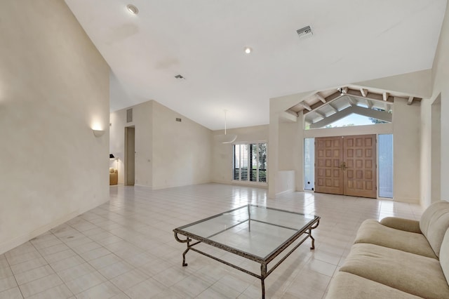 living room with light tile patterned flooring and high vaulted ceiling