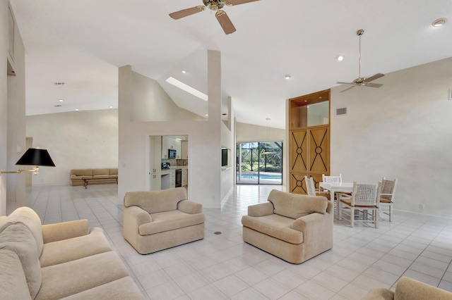 tiled living room featuring ceiling fan and high vaulted ceiling