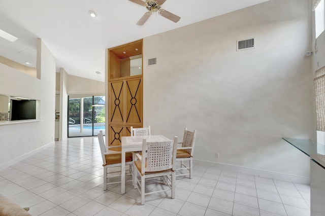 tiled dining room featuring ceiling fan and high vaulted ceiling