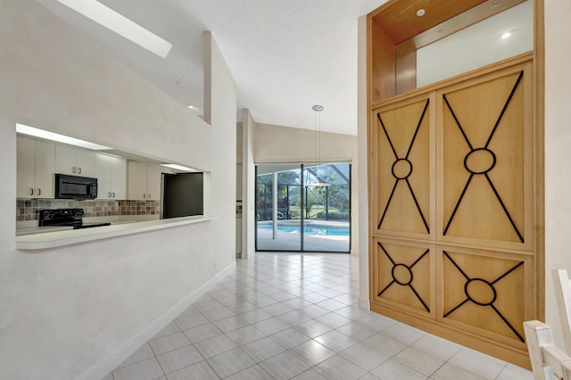 kitchen with white cabinetry, tasteful backsplash, light tile patterned floors, pendant lighting, and black appliances