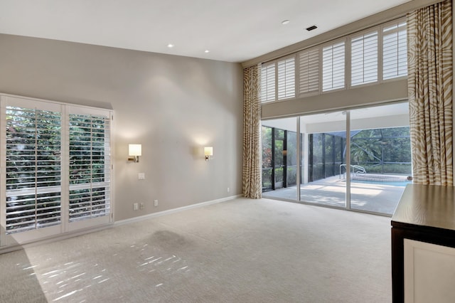 unfurnished living room featuring carpet and a towering ceiling