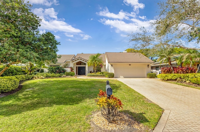 mediterranean / spanish house with a garage and a front lawn