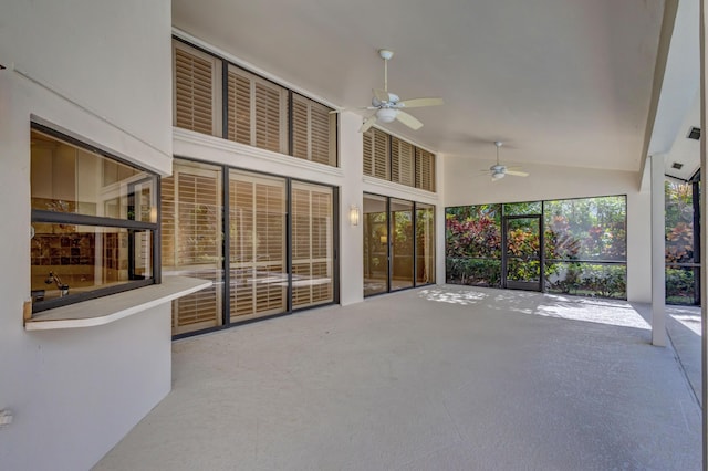 unfurnished sunroom with vaulted ceiling and ceiling fan