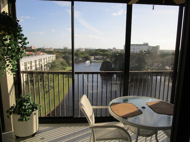 sunroom / solarium featuring a water view