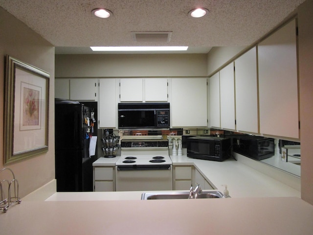 kitchen with white cabinetry, sink, a textured ceiling, and black appliances