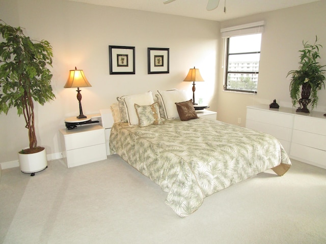 bedroom with ceiling fan and light carpet