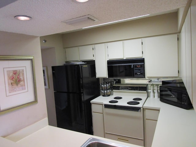 kitchen with white cabinetry, black appliances, and a textured ceiling