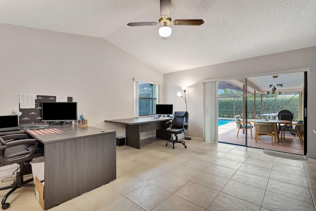 home office featuring a wealth of natural light, light tile patterned floors, a ceiling fan, and vaulted ceiling