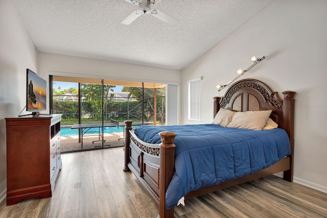 bedroom with access to outside, light wood-style flooring, and a textured ceiling