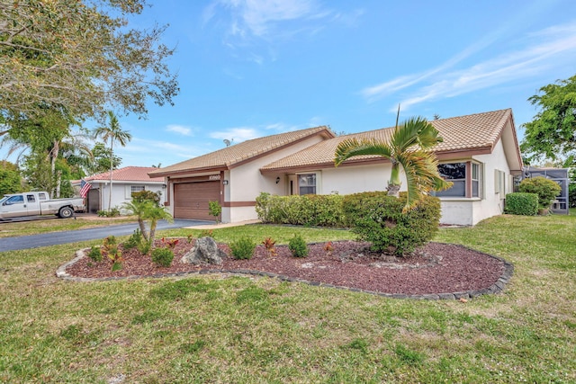 single story home with stucco siding, a front yard, a garage, driveway, and a tiled roof