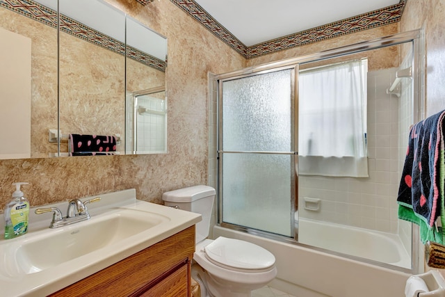 bathroom featuring vanity, toilet, and shower / bath combination with glass door