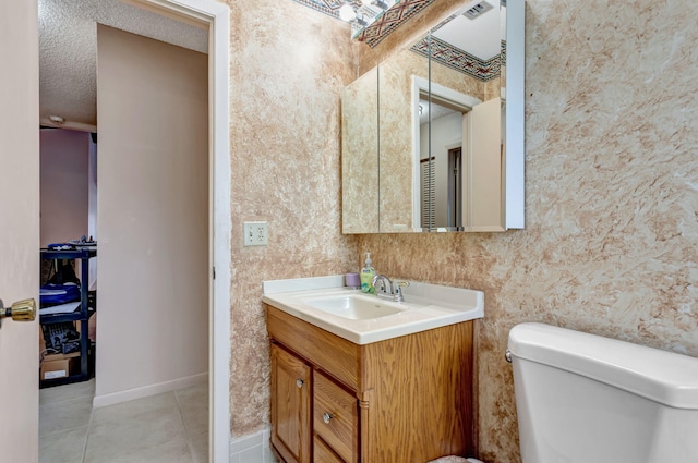 bathroom featuring tile patterned flooring, wallpapered walls, baseboards, toilet, and vanity