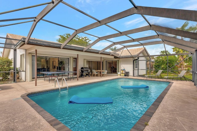 outdoor pool with glass enclosure, area for grilling, and a patio area