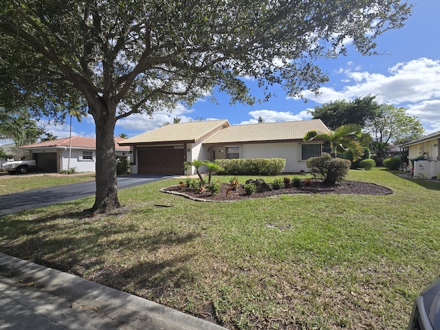 ranch-style home with a garage and a front yard