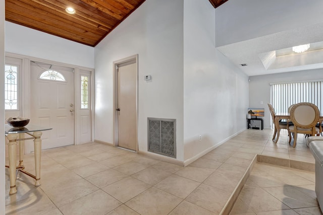 foyer featuring light tile patterned floors, visible vents, high vaulted ceiling, and wood ceiling