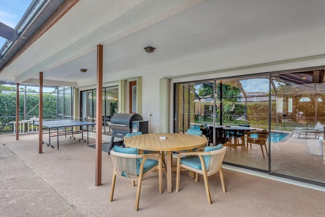 view of patio / terrace featuring glass enclosure, outdoor dining area, an outdoor pool, and a grill