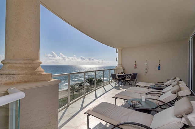 balcony featuring a beach view and a water view