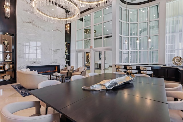 dining area featuring a towering ceiling and a fireplace