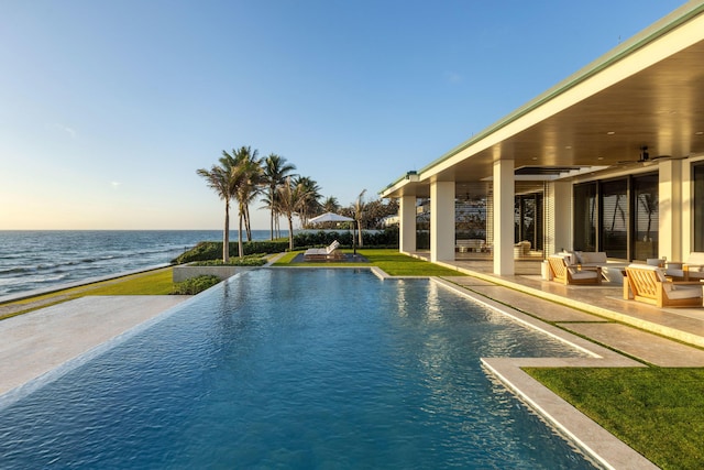 view of pool with a water view, an outdoor living space, a yard, and a patio