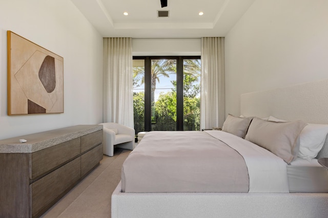 bedroom featuring a tray ceiling and access to outside