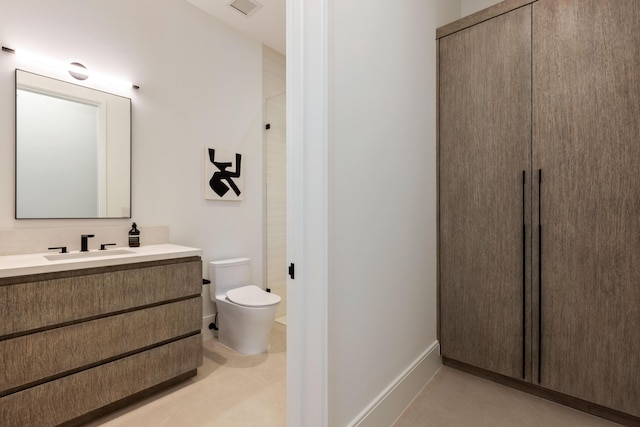 bathroom with toilet, vanity, and a shower with shower door