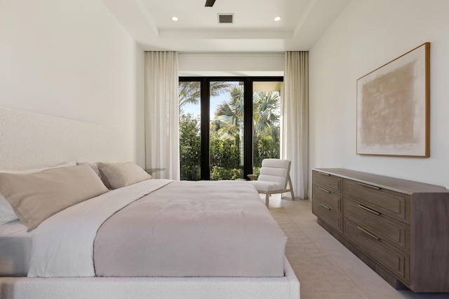 carpeted bedroom with a raised ceiling