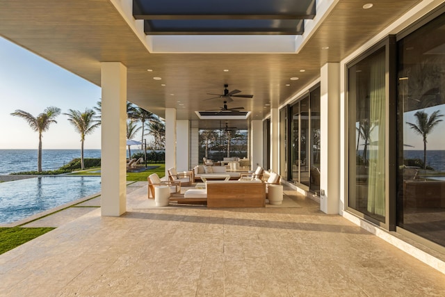 view of patio / terrace with a water view, ceiling fan, and an outdoor living space