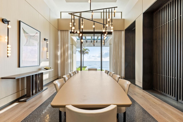 1160 S Ocean Blvd, Manalapan, FL 33462 - dining area featuring wood finished floors, a chandelier, and a water view