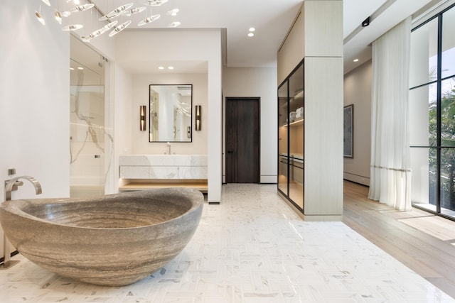 1160 S Ocean Blvd, Manalapan, FL 33462 - bathroom featuring walk in shower, vanity, a freestanding tub, and wood finished floors
