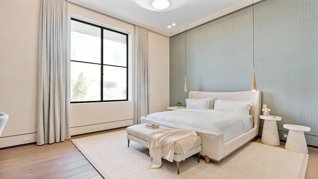 bedroom with light hardwood / wood-style floors and multiple windows