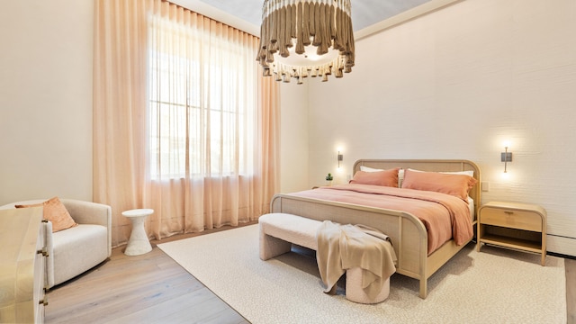 bedroom with hardwood / wood-style flooring and a notable chandelier