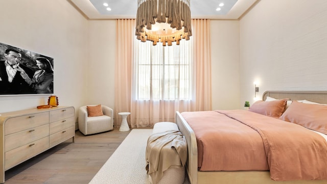 bedroom with ornamental molding and light hardwood / wood-style flooring