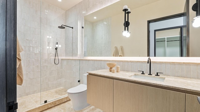 bathroom featuring tiled shower, vanity, and toilet