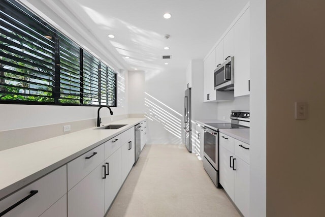 kitchen featuring sink, stainless steel appliances, and white cabinetry