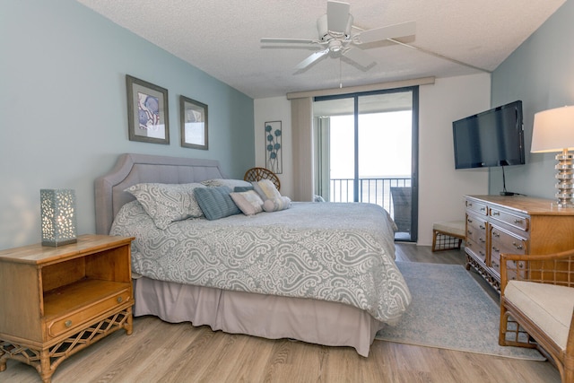 bedroom with ceiling fan, light hardwood / wood-style flooring, a textured ceiling, and access to outside