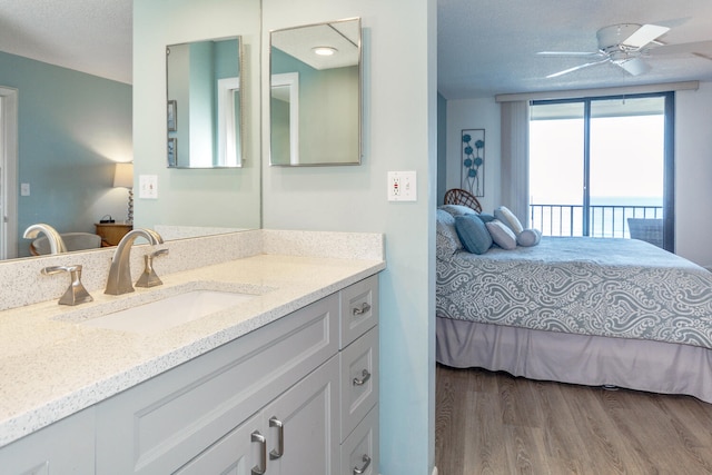 bedroom with sink, wood-type flooring, a textured ceiling, ceiling fan, and access to exterior