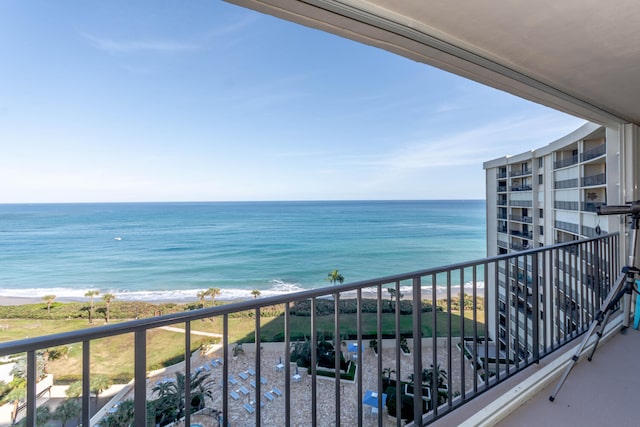 balcony featuring a view of the beach and a water view