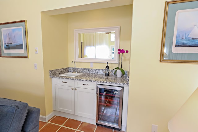 bar with white cabinetry, sink, wine cooler, light tile patterned floors, and light stone counters