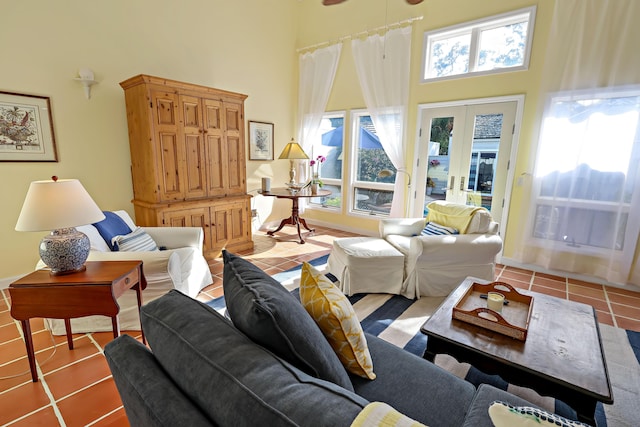 tiled living room featuring a towering ceiling and french doors