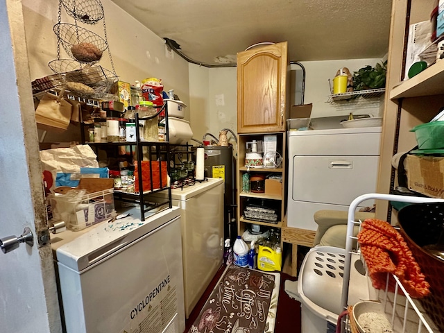 storage room with washing machine and dryer and water heater