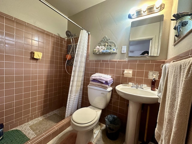 bathroom featuring tile walls, sink, a shower with curtain, and toilet