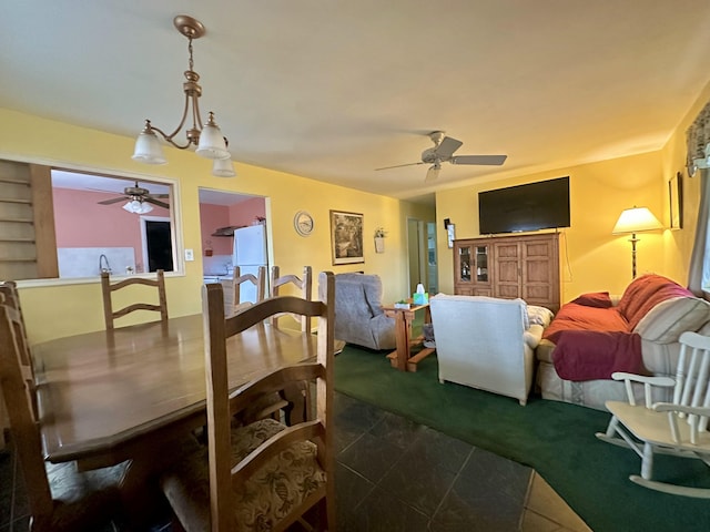 carpeted dining room featuring ceiling fan