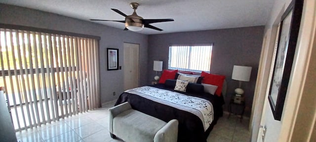 tiled bedroom with ceiling fan and a textured ceiling