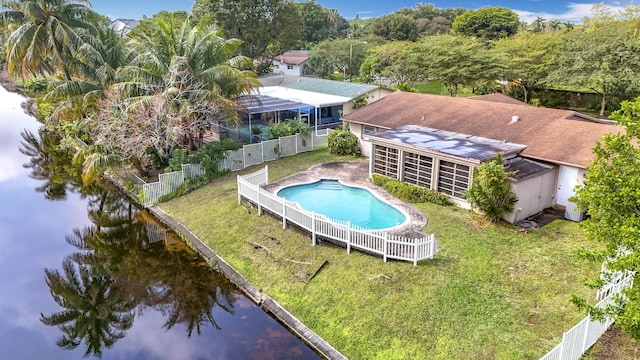 view of swimming pool with a yard, a sunroom, and a water view