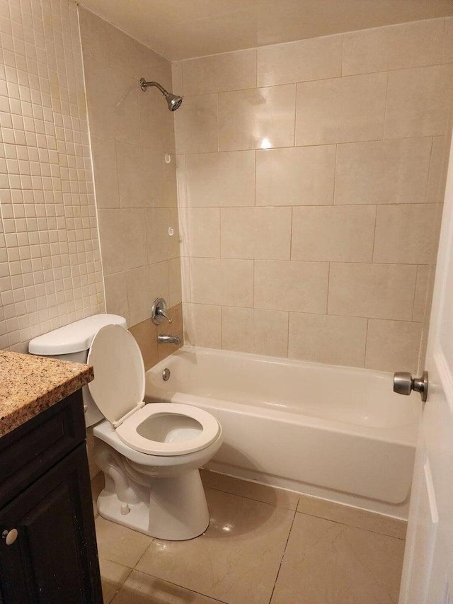 full bathroom featuring vanity, tile patterned flooring, toilet, and tiled shower / bath combo