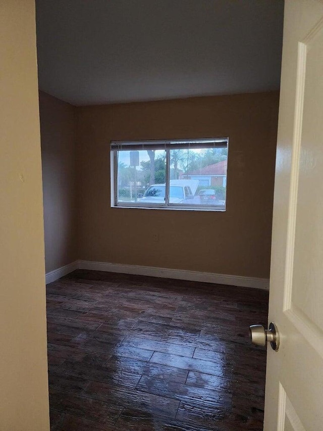 spare room with dark hardwood / wood-style floors